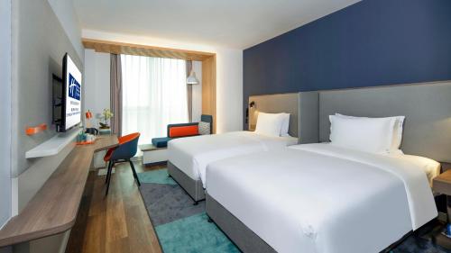 um quarto de hotel com duas camas e uma secretária em Holiday Inn Express Chengdu Tianfu Airport Zone, an IHG Hotel em Jianyang