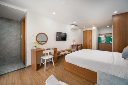 - une chambre avec un lit et un bureau avec un miroir dans l'établissement Samatha Apartment & Hotel, à Đà Nẵng