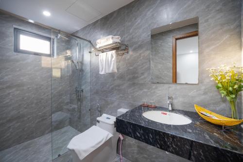 La salle de bains est pourvue d'un lavabo et d'une douche en verre. dans l'établissement Samatha Apartment & Hotel, à Đà Nẵng