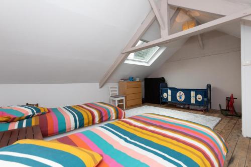 a attic bedroom with two beds and a crib at la petite maison du Portrieux in Saint-Quay-Portrieux