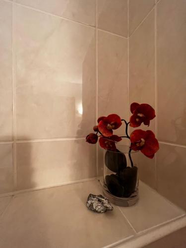 a vase with red flowers sitting on a table at Rosenfeld 2 in Pinneberg