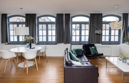 a living room with a couch and a table at Appartement La Charrette in Tilburg