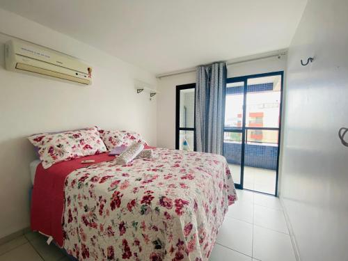 - une chambre avec un lit rouge et une fenêtre dans l'établissement Flat Apartamento, 50m da praia, à João Pessoa