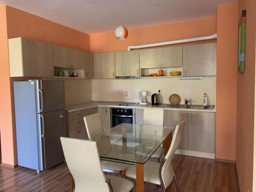uma cozinha com uma mesa de vidro e um frigorífico em Private Apartment in Golden Sands - Aquamarine Odessos em Golden Sands