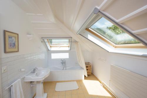 a bathroom with a sink and a bath tub at Maison Suchard, tradition & elegance in the Jura in Couvet