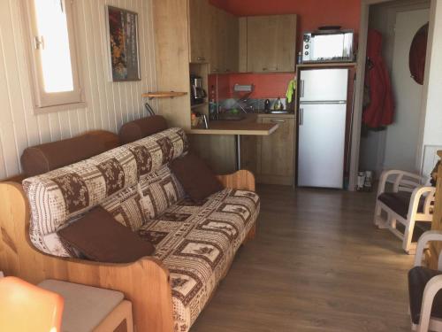 uma sala de estar com um sofá e uma cozinha em La Récré em Laye