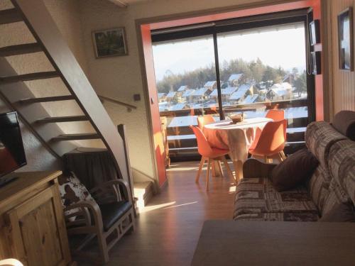 a living room with a staircase and a table and chairs at La Récré in Laye