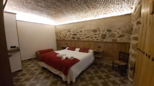 a bedroom with a large bed with a red blanket at La casina de Carmina in Arroyomolinos de Montánchez