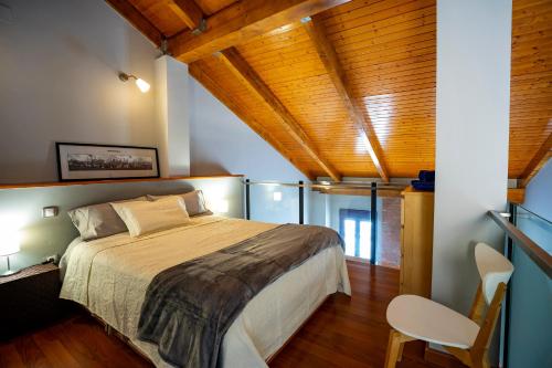 um quarto com uma cama grande num quarto com tectos em madeira em LOFT BETANIA em Cáceres