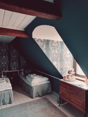 a attic room with two beds and a window at Weinbergs in Trelleborg