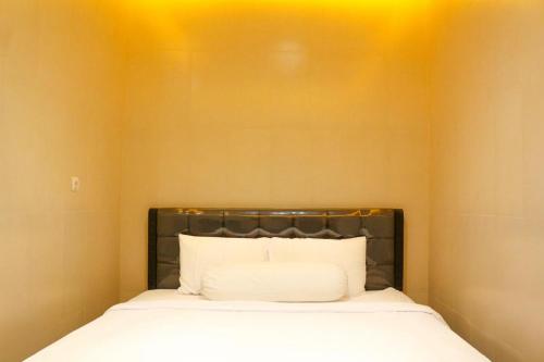 Un pat sau paturi într-o cameră la HP Residence Mitra RedDoorz near Alun Alun Kediri