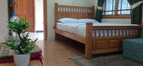 a bedroom with a bed with a wooden frame at Families Only! Eagle Nest Cottage Muzaffarabad by LMC in Muzaffarabad