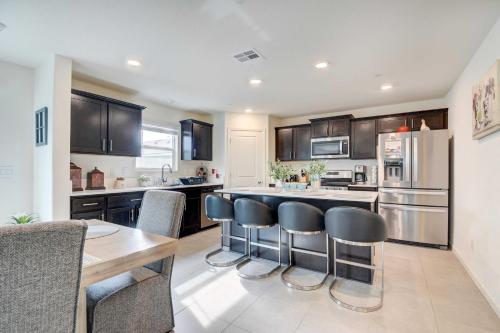 a kitchen with black cabinets and a table and chairs at Spacious Merced Vacation Rental! in Merced