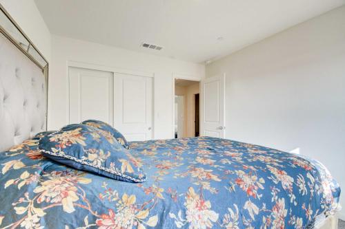 a bedroom with a bed with a blue blanket and pillows at Spacious Merced Vacation Rental! in Merced