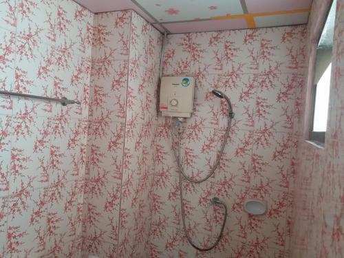 łazienka z prysznicem i czerwonymi kwiatami na ścianie w obiekcie Merit Mansion w mieście Bangkok