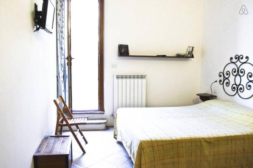 ヌマーナにあるTra Gli Olivi E La Riviera Del Coneroのベッドルーム1室(ベッド1台、椅子、窓付)