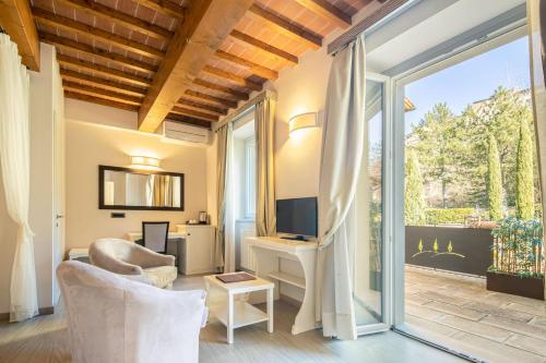a living room with a tv and a sliding glass door at Beautiful villa with private lawn, pool and luxury SPA by VacaVilla in Poppi