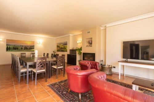 a living room with red furniture and a dining room at Beautiful villa with private lawn, pool and luxury SPA by VacaVilla in Poppi