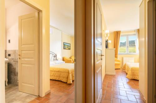 a hotel room with two beds and a bathroom at Beautiful villa with private lawn, pool and luxury SPA by VacaVilla in Poppi