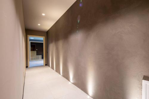 a hallway with a gray wall and a window at Beautiful villa with private lawn, pool and luxury SPA by VacaVilla in Poppi