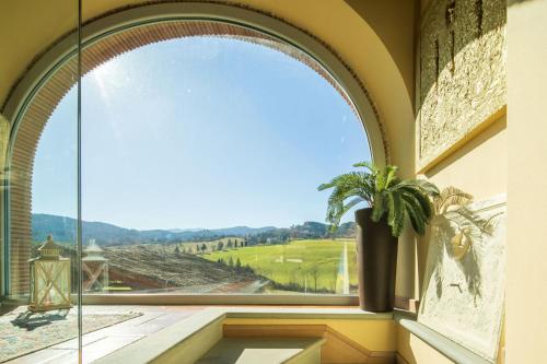 an arched window in a building with a potted plant at Beautiful villa with private lawn, pool and luxury SPA by VacaVilla in Poppi