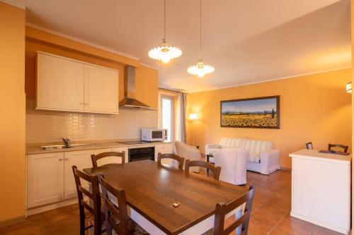 a kitchen and living room with a wooden table and chairs at Beautiful villa with private lawn, pool and luxury SPA by VacaVilla in Poppi