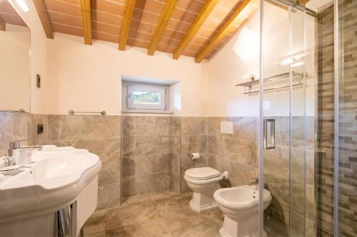 a bathroom with a toilet and a sink and a shower at Beautiful villa with private lawn, pool and luxury SPA by VacaVilla in Poppi