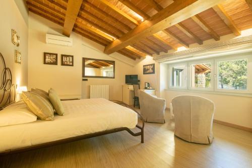 a bedroom with a bed and chairs in a room at Beautiful villa with private lawn, pool and luxury SPA by VacaVilla in Poppi
