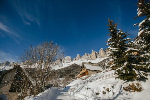 a snow covered mountain with a house and a tree at ETERPA Les chalets de Pré Clos en Vercors in Saint-Andéol