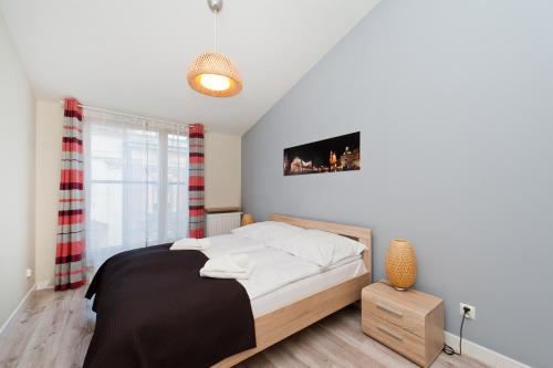 um quarto com uma cama e uma televisão na parede em Apartamenty Sun & Snow Kraków Browar Lubicz na Cracóvia