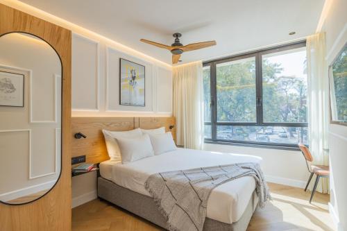 a bedroom with a bed and a large window at The Arbel Tel Aviv in Tel Aviv
