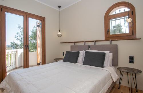 a bedroom with a large white bed and a window at Adriana di Levante by "elite" in Ayios Kirikos