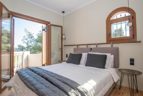 a bedroom with a large bed and a large window at Adriana di Levante by "elite" in Ayios Kirikos