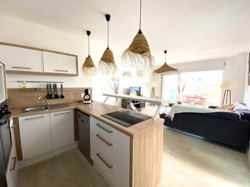 a kitchen with a counter top and a living room at Ti Pêcheurs vb Bord de mer in Saint-Pierre