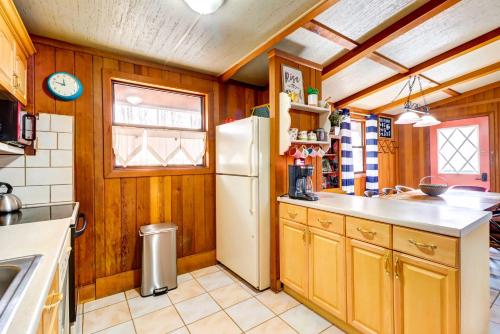a kitchen with wooden walls and a white refrigerator at Pet-Friendly Home with Deck at Big Bass Lake! in Gouldsboro