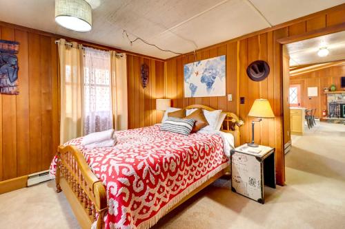 a bedroom with a bed with a red and white blanket at Pet-Friendly Home with Deck at Big Bass Lake! in Gouldsboro
