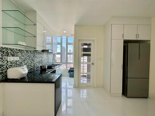 a kitchen with white cabinets and a black counter top at Infinity 28 Hotel and Residence in Phnom Penh