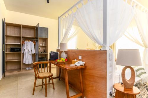 a kitchen with a wooden table and a refrigerator at TOA Hotel & Spa Zanzibar in Pongwe