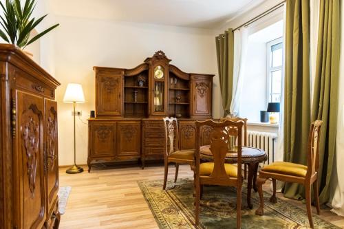 comedor con mesa y reloj de abuelo en Doma3 Luxury Vilnius Apartment, en Vilna