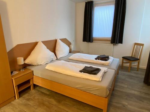 a bedroom with two beds and a window at Tempel-inn Appartements Molkereistr. 2 in Werlte