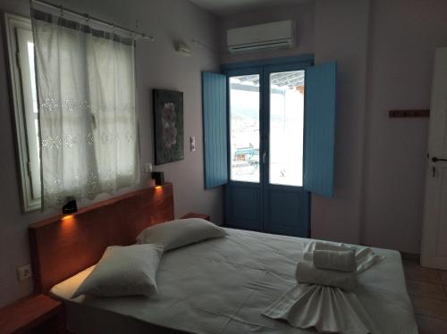 a bedroom with a large bed and a window at Amorgaia 2 in Katapola