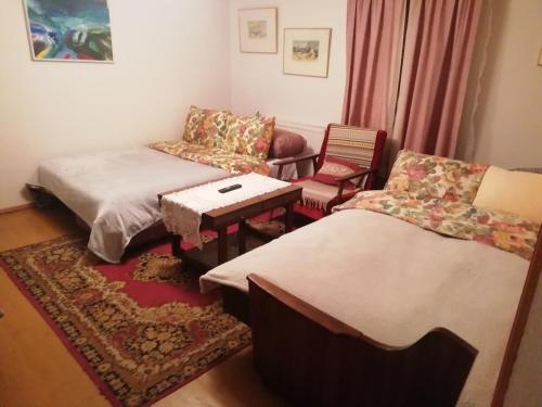 a room with two beds and a couch and a table at Poilsio kambariai Salake in Salakas