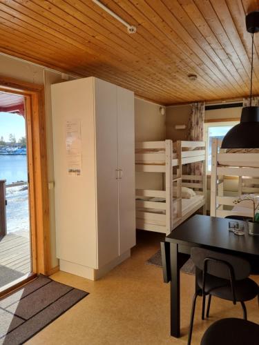 a room with a table and a room with bunk beds at Måvikens Camping in Måviken