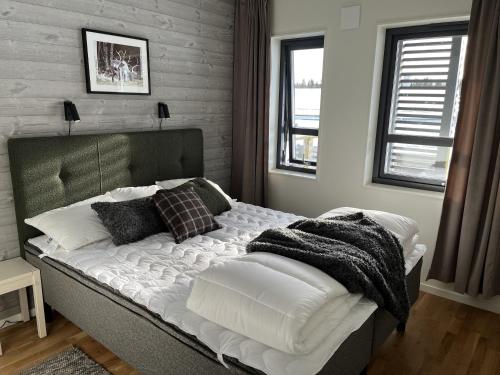 a bedroom with a bed with white sheets and pillows at Funäs Fjällby Funäsdalen in Funäsdalen