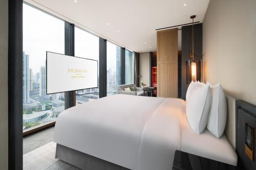 a bedroom with a large white bed and a large window at Mumian Chengdu, in The Unbound Collection by Hyatt in Chengdu