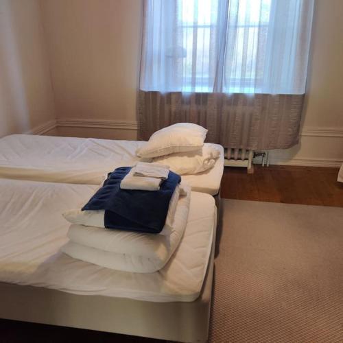 a bedroom with two beds with white sheets and pillows at 2 bedroom apartment in Södertälje