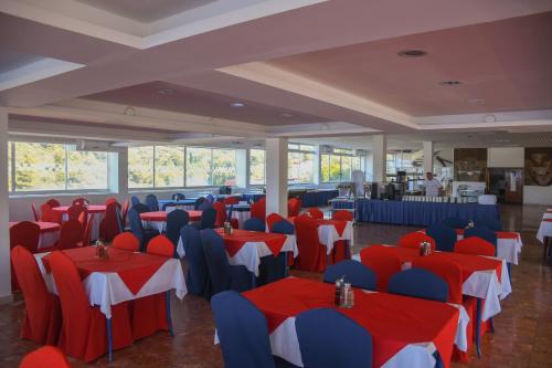 un salón de banquetes con mesas y sillas rojas y azules en Hotel Sirena Hvar en Hvar