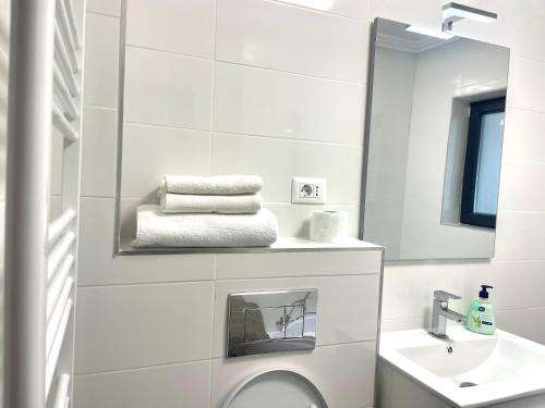 a white bathroom with a sink and a mirror at Cleopatra 3 in Ipoteşti