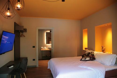 pokój hotelowy z łóżkiem i telewizorem w obiekcie Il Giardino Segreto w mieście Fogliano Redipúglia