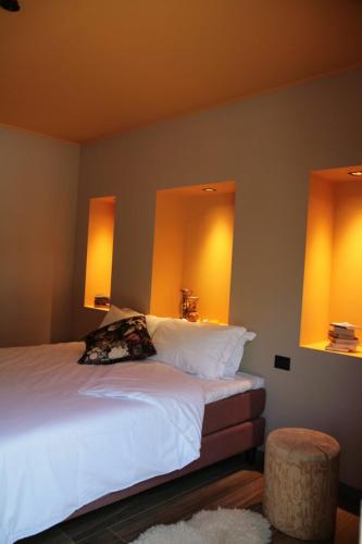1 dormitorio con 1 cama con 2 luces en la pared en Il Giardino Segreto, en Fogliano Redipúglia